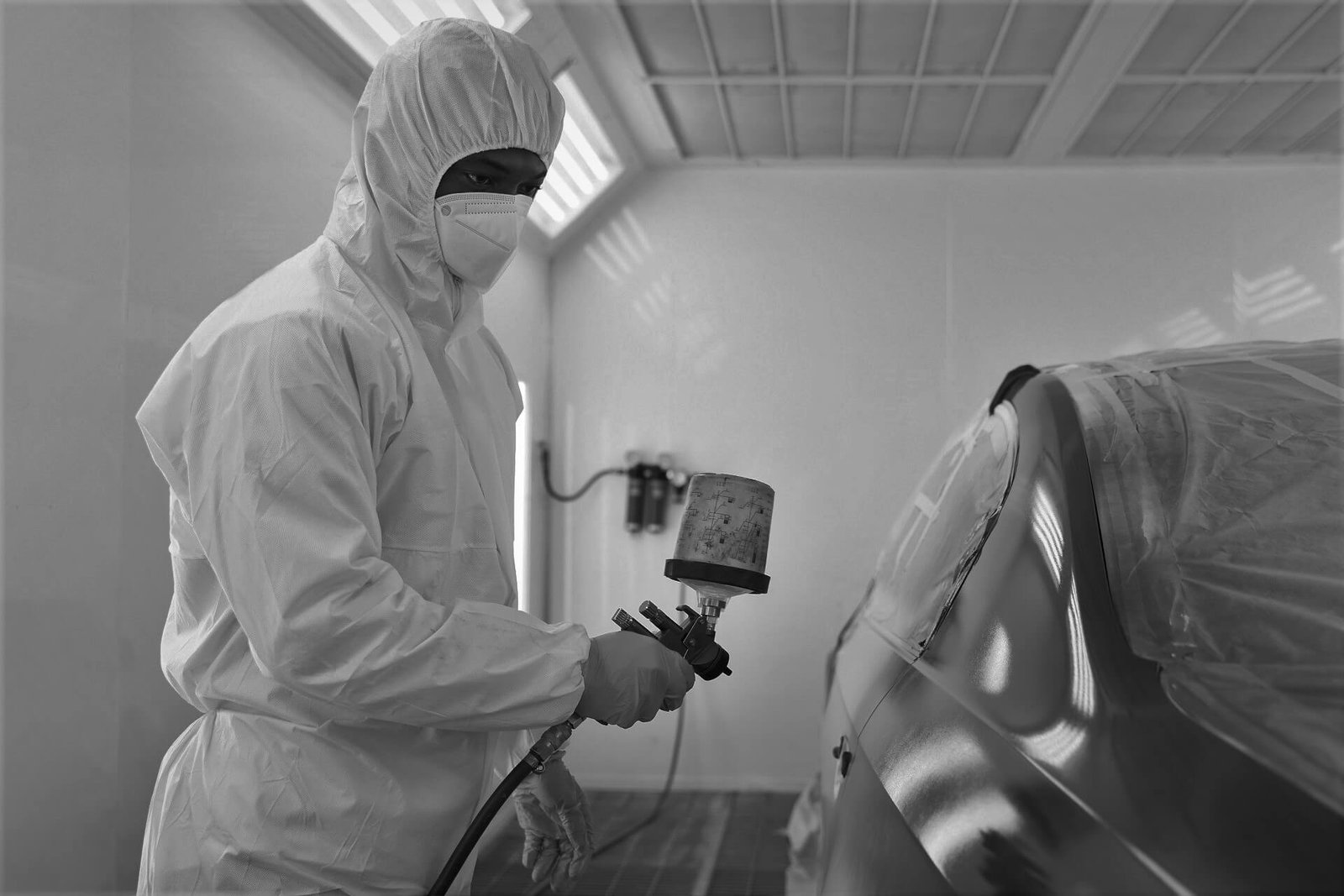 Technician preparing a vehicle panel for automotive painting