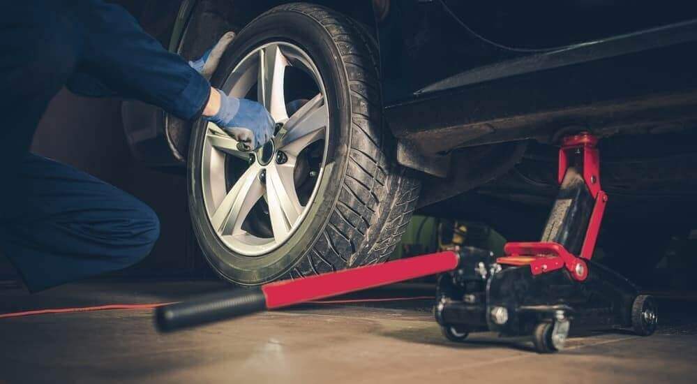 Technician checking Chevrolet tyre size, wheel and tread condition