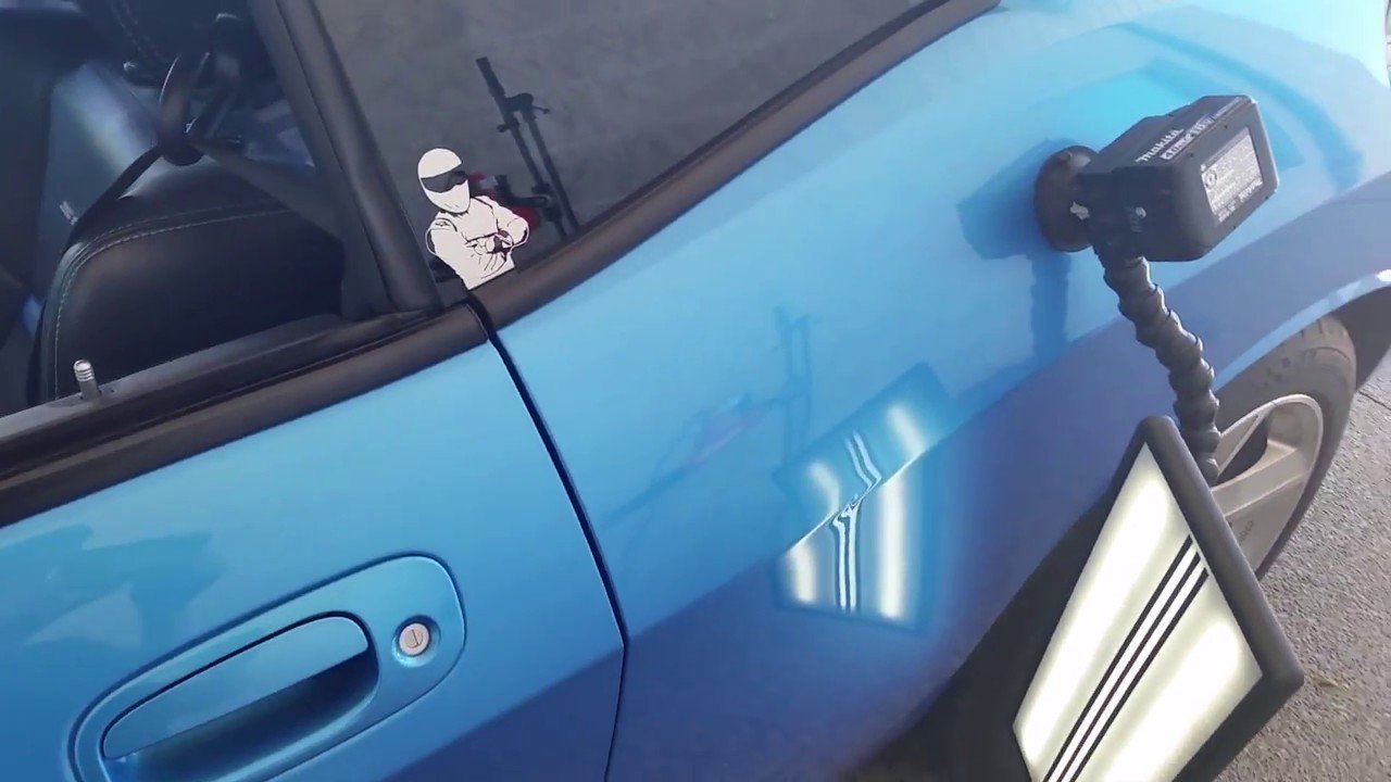 Technician checking a Dodge body panel dent
