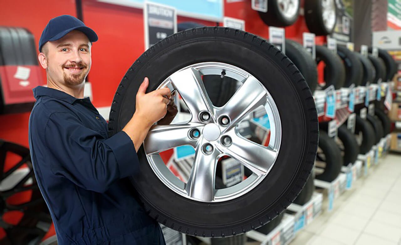 Mechanic checking a tire before using a car air pump