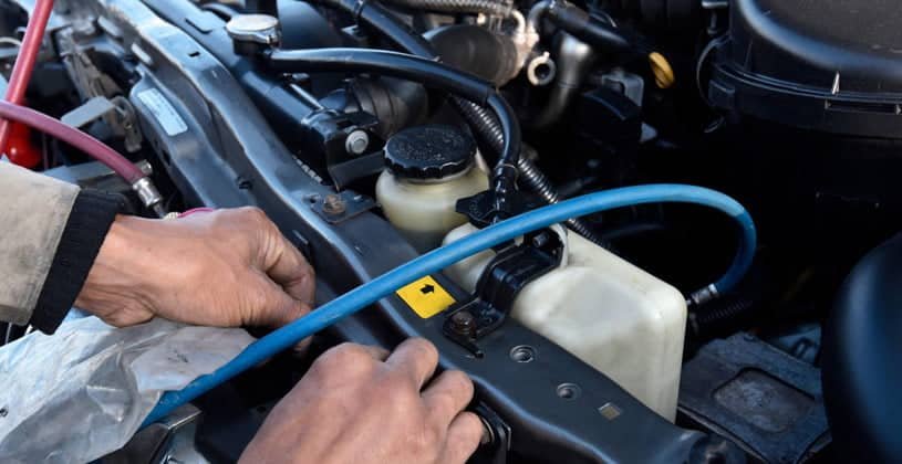 Technician checking an automotive air-conditioning system in a workshop