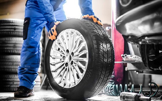 Technician rotating a tire during workshop service