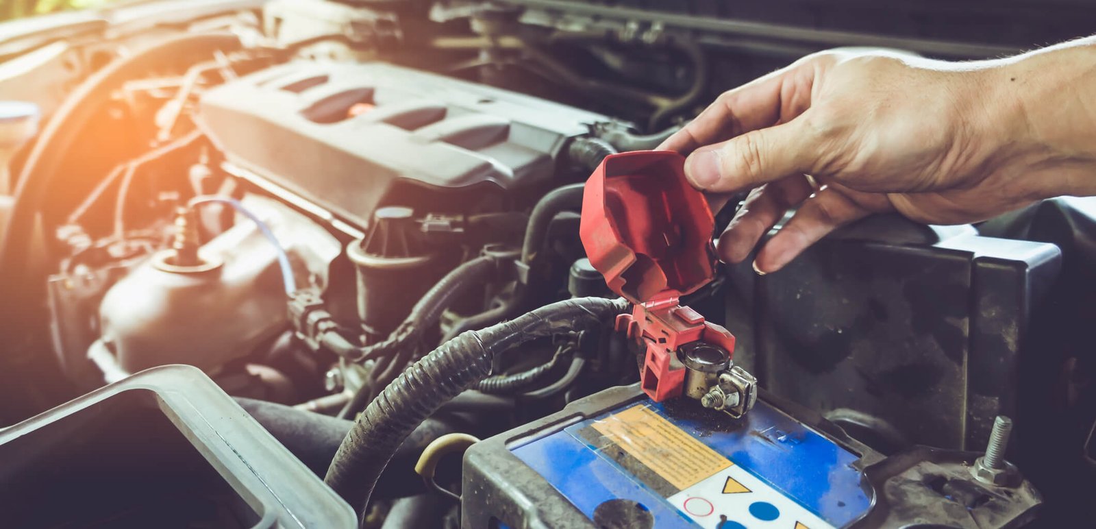 Battery terminal and protective cover in an engine bay
