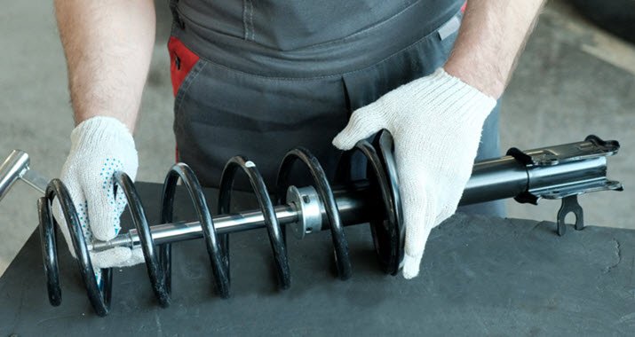 Jaguar suspension strut and coil spring being inspected