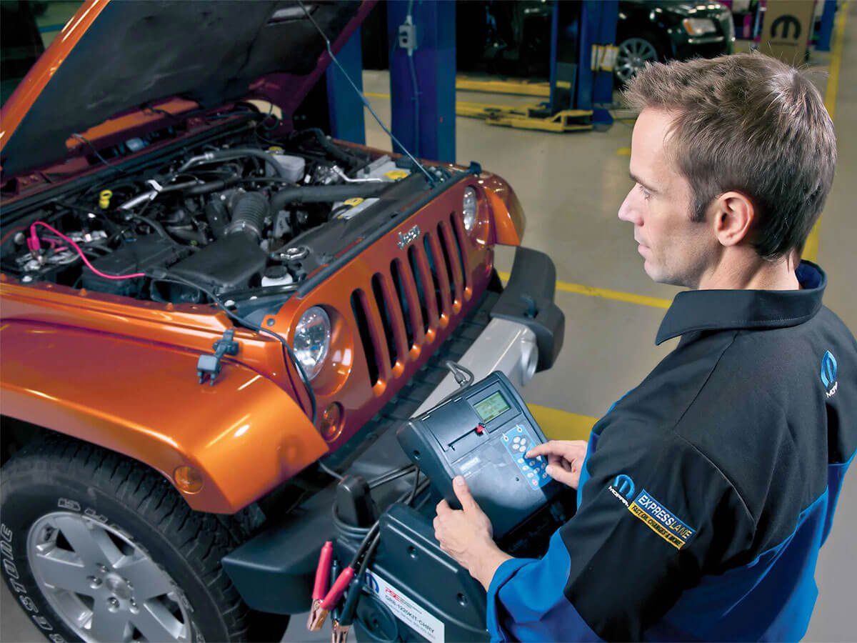 Technician checking a Jeep battery and electrical connections
