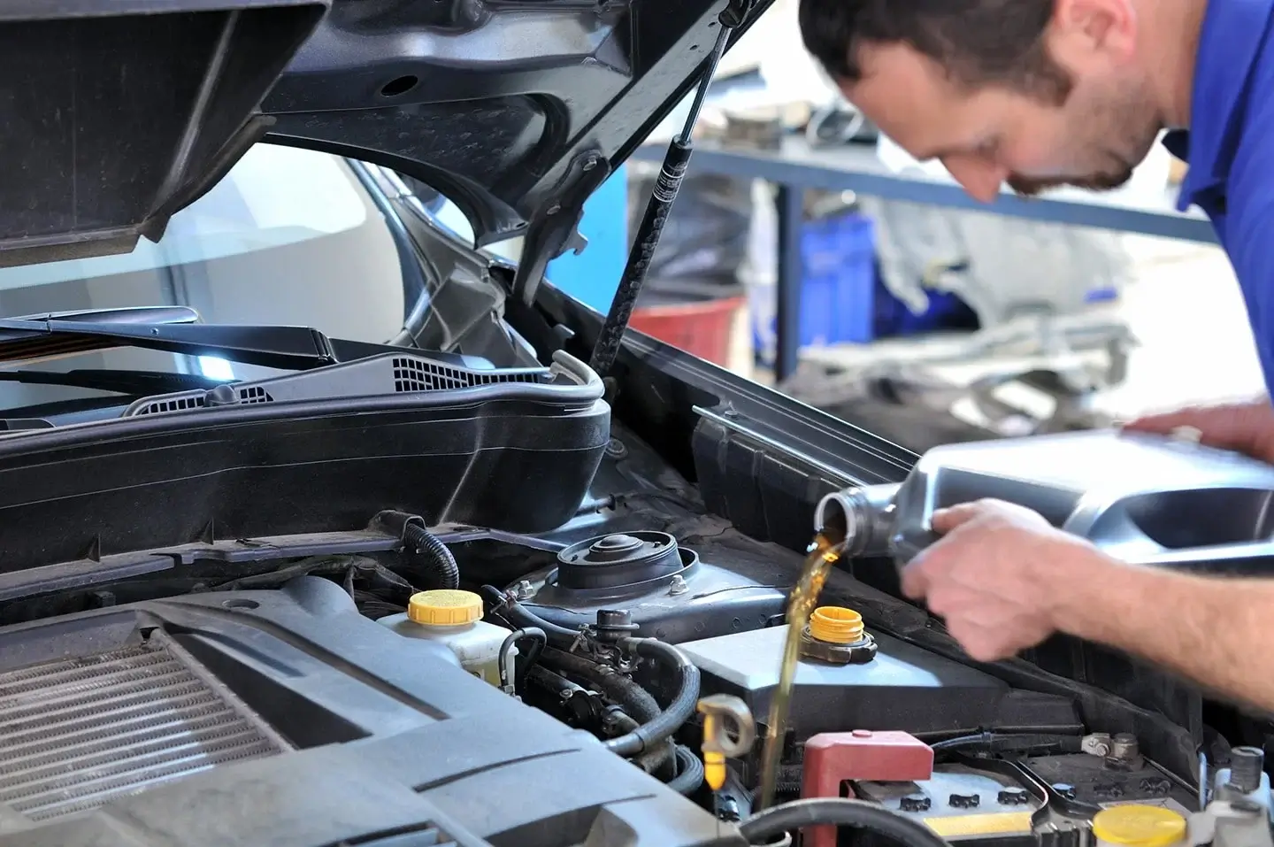 Technician adding fresh engine oil during a Jeep oil change in Dubai