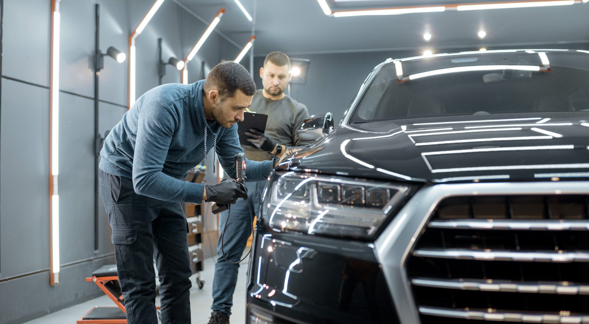 Technician inspecting Volkswagen body damage and paint condition