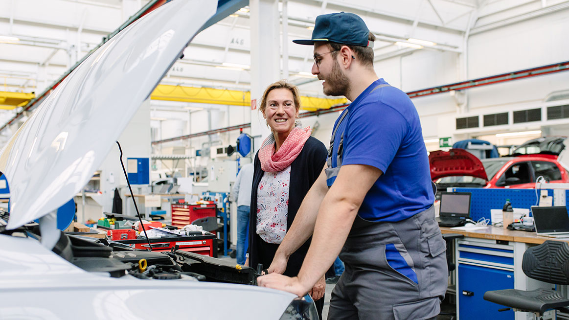 Volkswagen owner discussing an inspection with a workshop technician