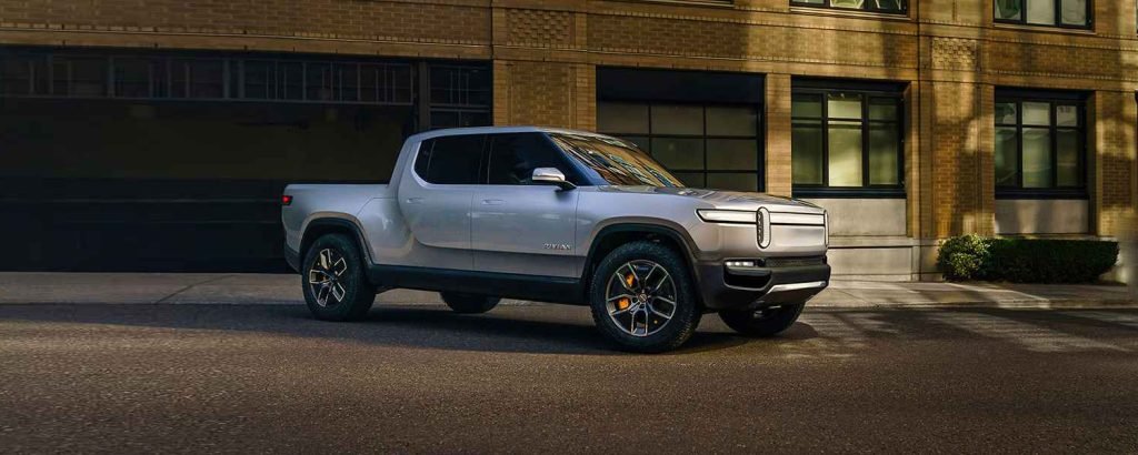 White Rivian R1T parked outside a building