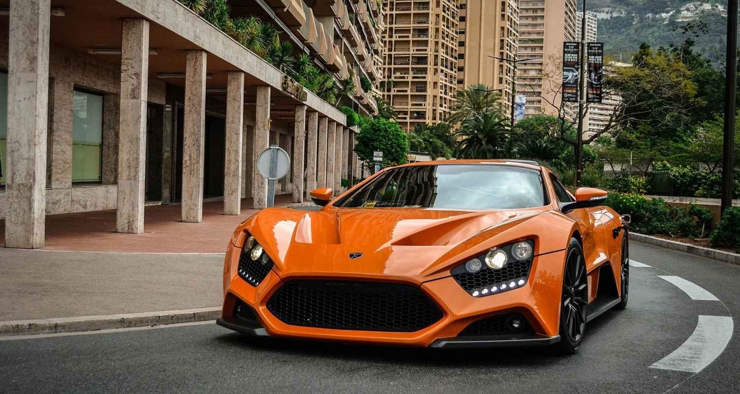 Orange Zenvo hypercar parked on a city street