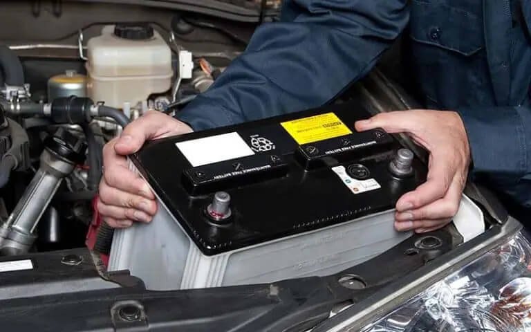 Car battery being fitted with terminals and mounting checked