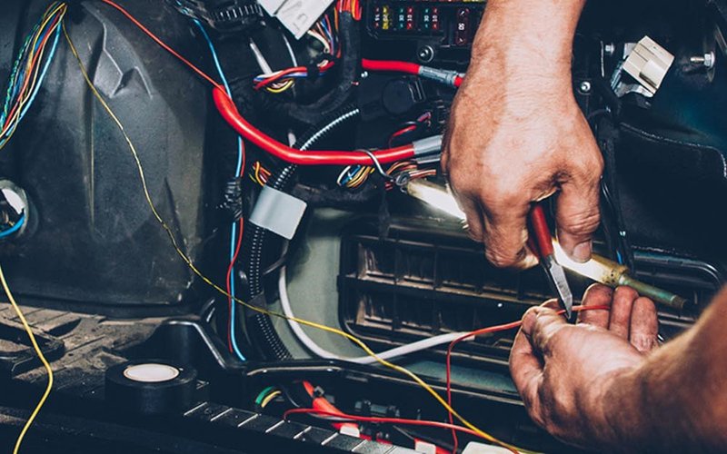 Technician diagnosing a car electrical problem