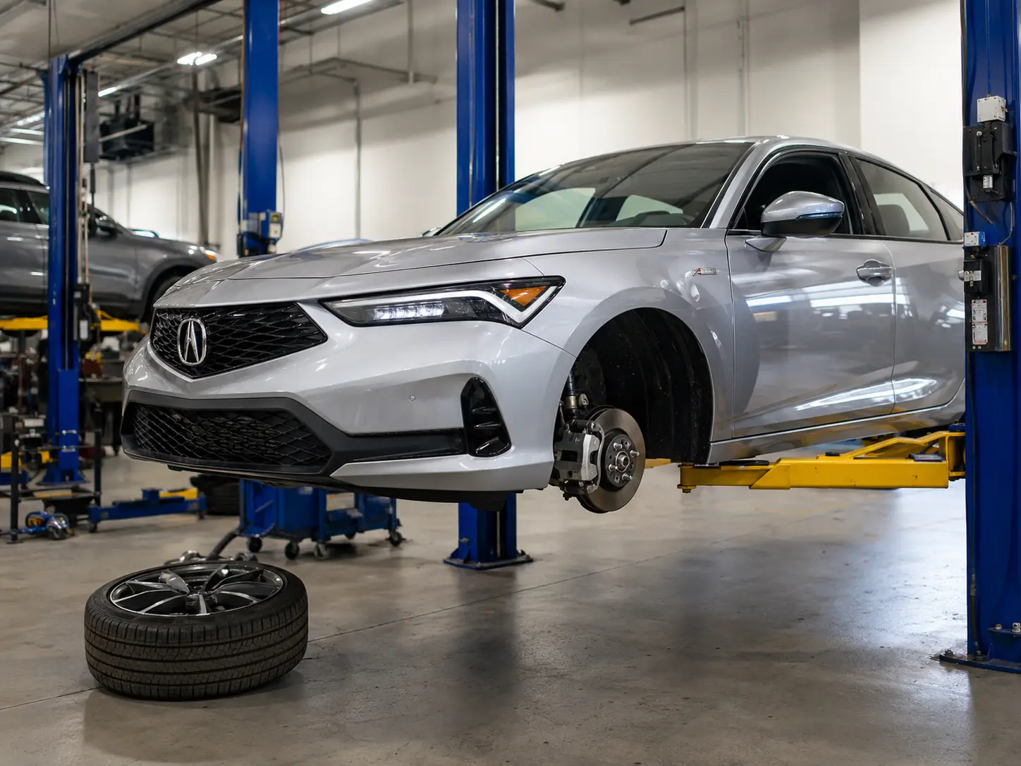 Acura Integra positioned on an automotive workshop lift