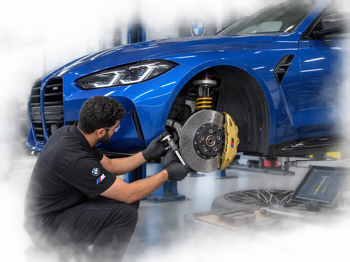 Technician inspecting brakes and suspension on a current BMW M3