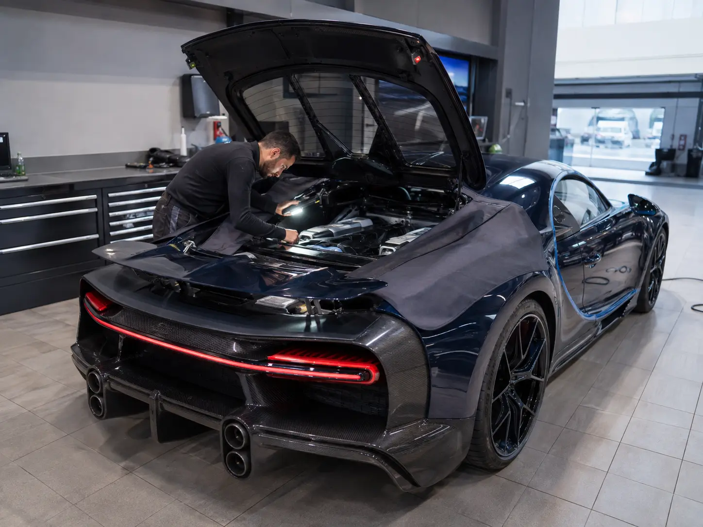 Bugatti Chiron in a workshop scene near an open engine area