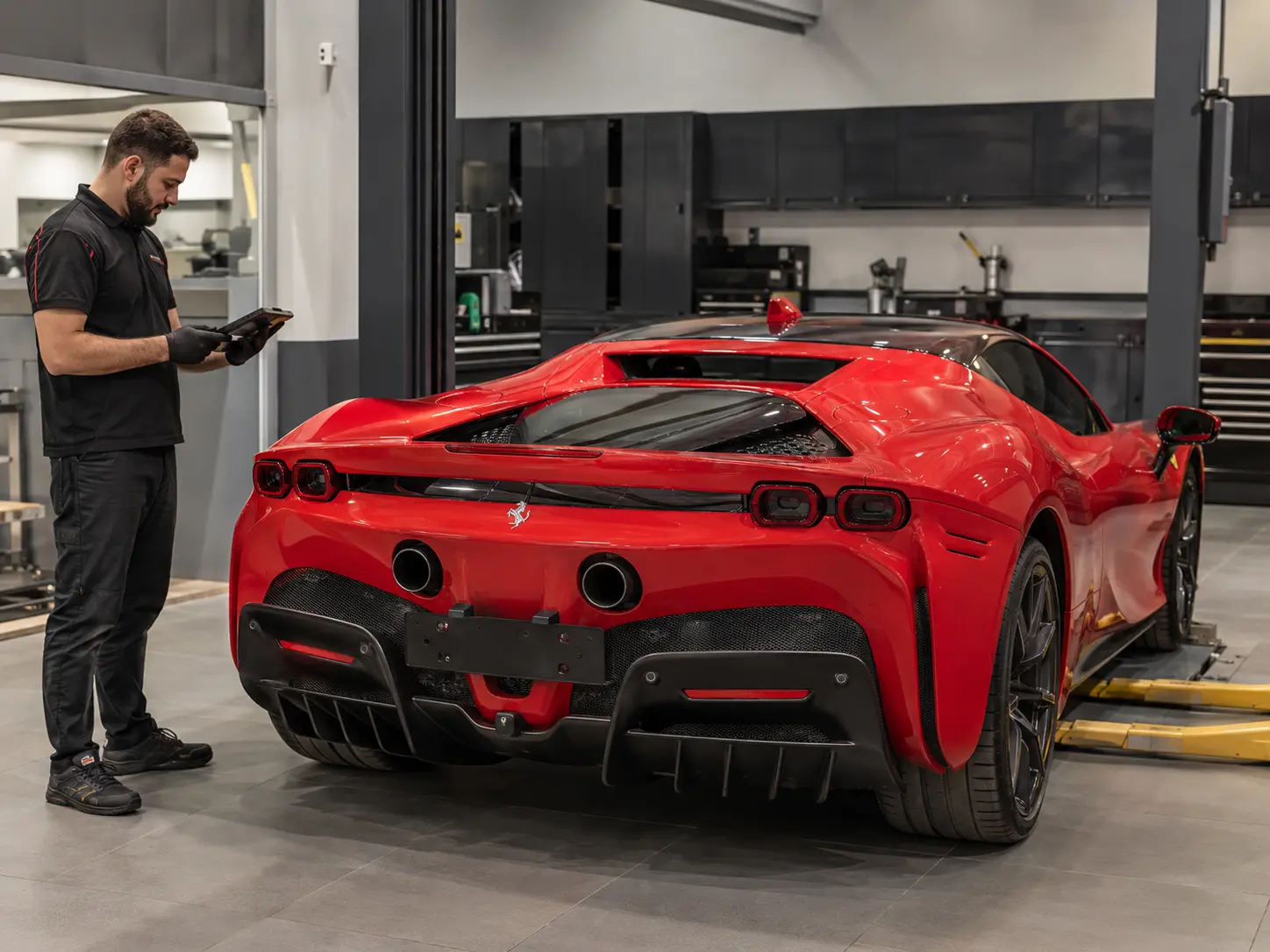 Technician carrying out a low-voltage systems verification on a current Ferrari SF90 without energized high-voltage repair