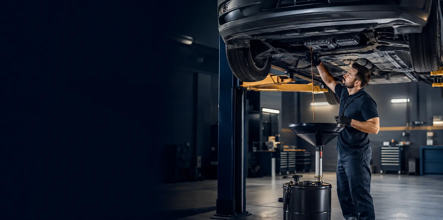 Technician draining automatic transmission fluid from a passenger car in a Dubai workshop