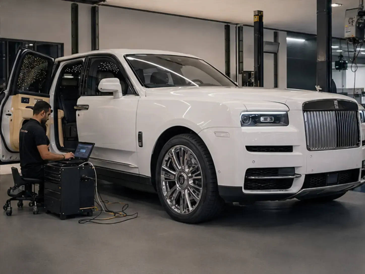 Technician completing low-voltage and cabin-system verification on a modern Rolls-Royce Cullinan