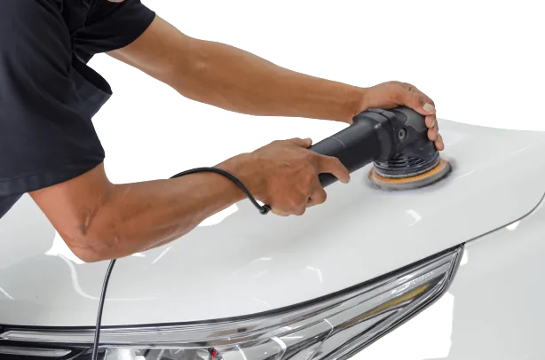 Machine polisher working on a white car bonnet