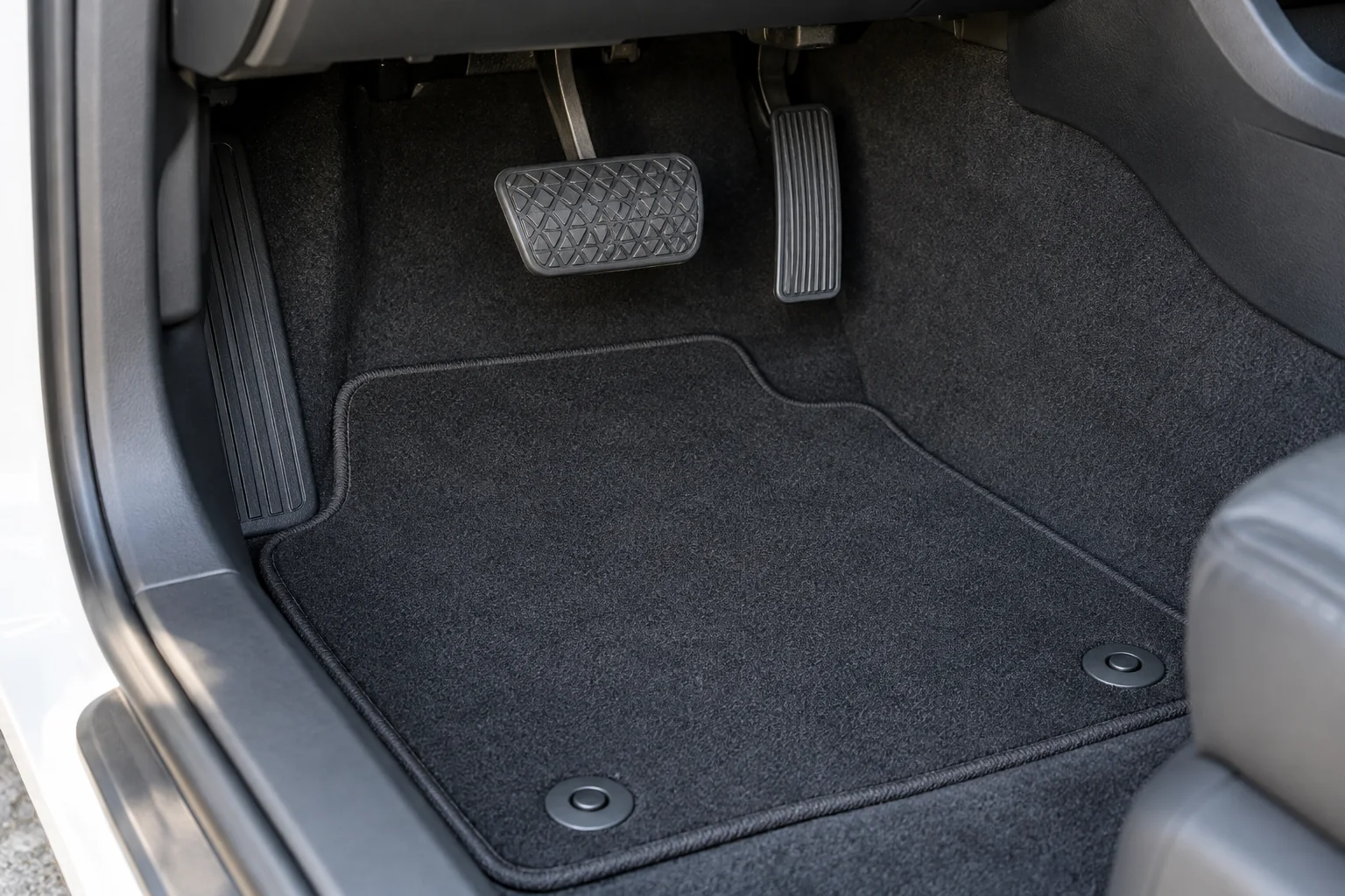 Secured floor mat clear of the accelerator and brake pedals